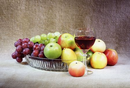 Classical still-life with fruit and a wineglass against a canvasの写真素材