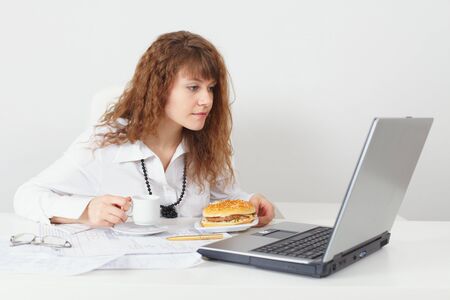 The young beautiful woman was going to eat behind a table at officeの写真素材