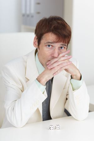 The young businessman in a white suit sits at a tableの写真素材