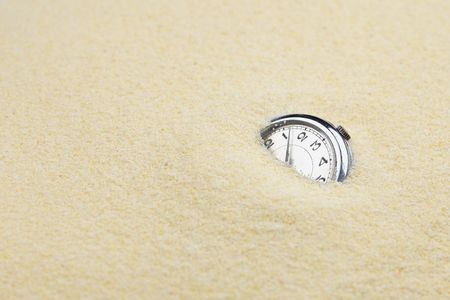 Ancient mechanical watch sinks in sand symbolize leaving timeの写真素材