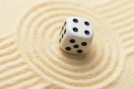 Dice on a sand surface - an abstract art composition in yellow tonesの写真素材