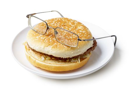 Amusing sandwich in spectacles lying on a plate isolated on a white backgroundの写真素材
