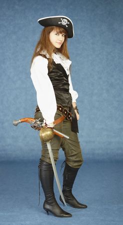 The young woman in clothes of the pirate on a dark blue backgroundの写真素材