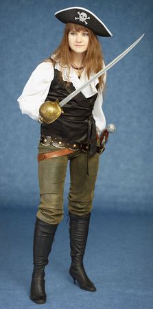 The young woman in clothes of the pirate on a dark blue backgroundの写真素材