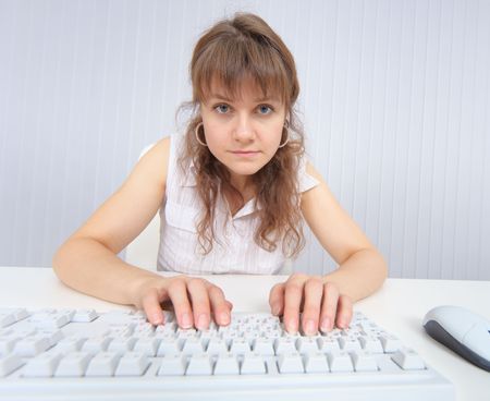 The comical woman sits in front of the monitor with the keyboardの写真素材
