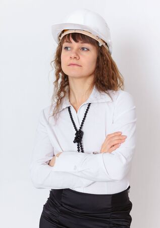 The serious young woman the engineer - builder in a white helmetの写真素材