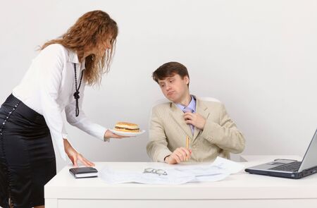 The secretary serves the Chief sandwich, in the workplace in the officeの写真素材