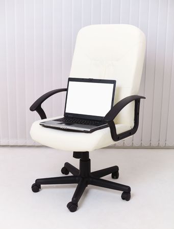 Laptop sits in a leather chair for the managerの写真素材