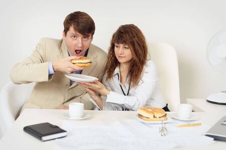 Two young businessmen lunching at the workplaceの写真素材