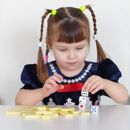 A child playing with small toys, sitting at the tableの写真素材