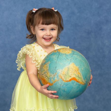 Beautiful little girl with the geographic globeの写真素材