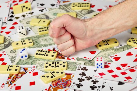 The hand clenched in a fist strikes the playing cardsの写真素材