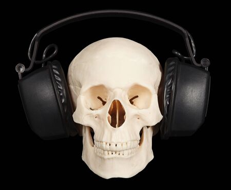 The human skull with stereo headphones on a black backgroundの写真素材