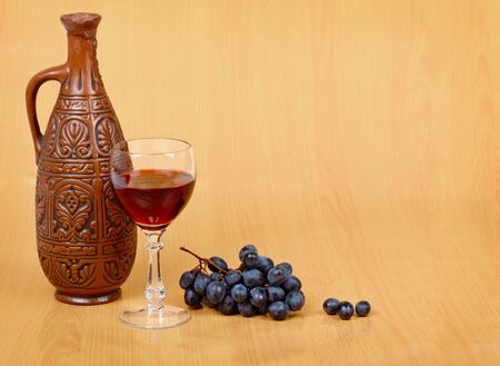 Artistic composition of the crock, glass and grapesの写真素材