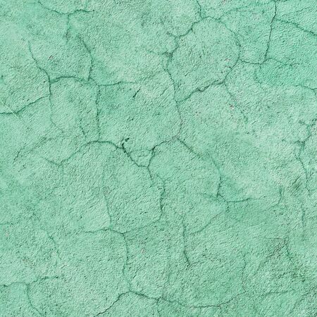 The texture of the green concrete wall covered with cracksの写真素材