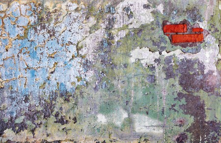 A wall with a hole through which to see a red brickの写真素材
