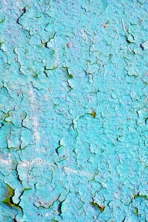 The blue paint is chipping on the surface of the wallの写真素材