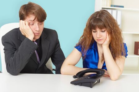 Young people are waiting for a phone call in officeの写真素材