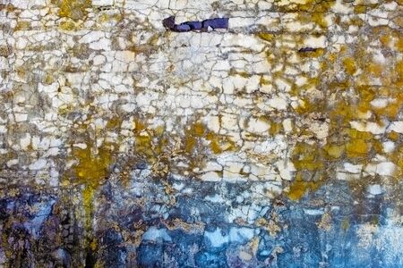 The old concrete wall with colored spots and cracksの写真素材