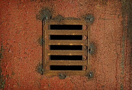 Old lattice on a steel rusty wall - an industrial backgroundの写真素材