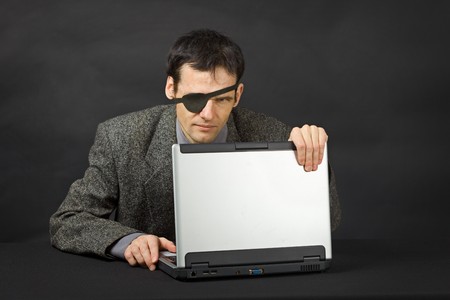 The computer pirate look with one eye on dark backgroundの写真素材