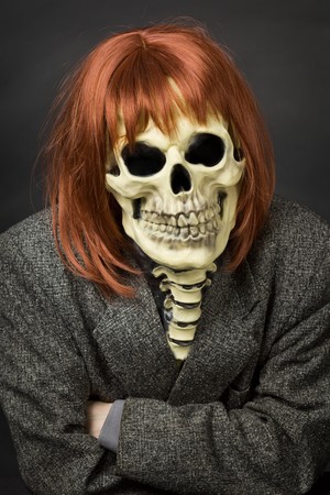The person in a mask of death from latex and a red wigの写真素材