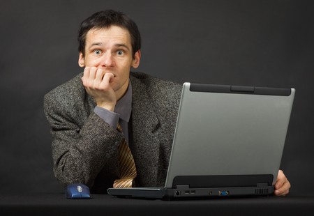 The surprised person with the computer. Sits and thinks.の写真素材