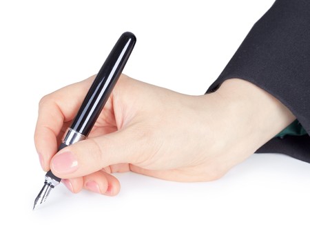 The female hand holds a pen, is isolated on a white backgroundの写真素材