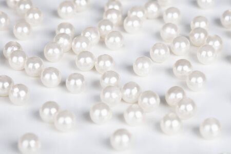 A lot of the false pearls are scattered on a tableの写真素材