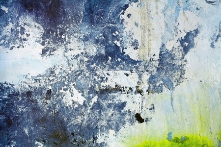 Ragged concrete wall with color stains of a paint