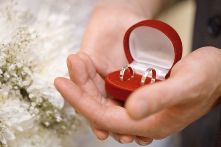 Hands of the groom and the bride hold a casket with rings close upの写真素材