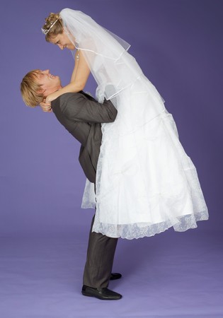 The strong groom holds the admired bride on handsの写真素材