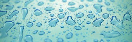 Water drops on a surface of dark blue plasticの写真素材