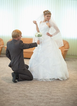 The groom with the bride funny pose in a ceremonial  hallの写真素材