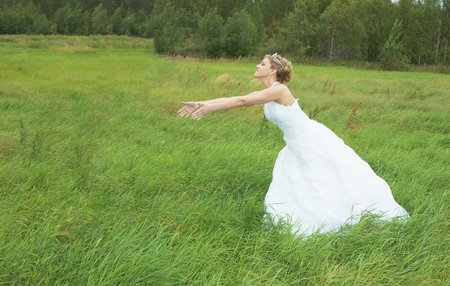 The bride hastens towards to the groom on a green meadowの写真素材