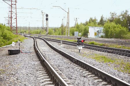 Railroad tracks, traffic lights and switches near railway stationの写真素材