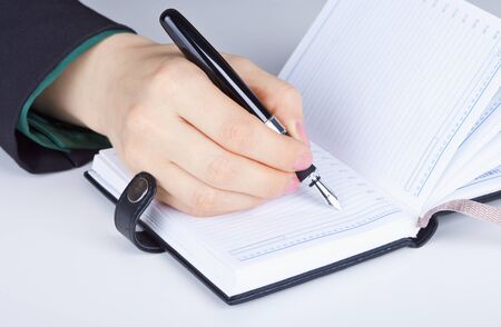 The women's hand and writes in diaryの写真素材