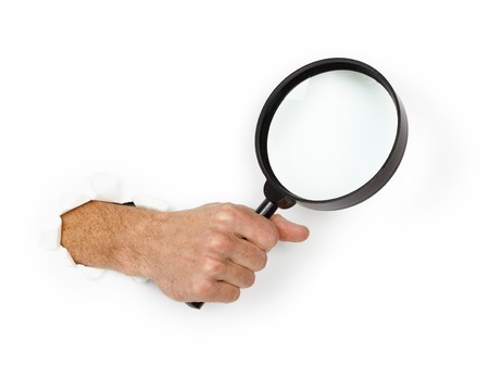 Male hand holding a magnifying glass on a white backgroundの写真素材