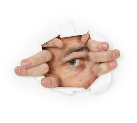 A man looks through a hole in the paperの写真素材