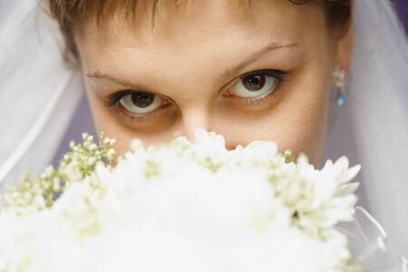 The eyes of the bride and bridal bouquet closeupの写真素材