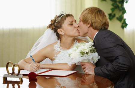 The bride and groom kiss during the ceremony of marriageの写真素材