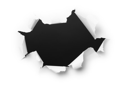 Big, dark hole in the white paperの写真素材