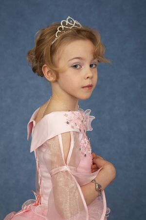 Little girl in fashionable dress on a blue backgroundの写真素材