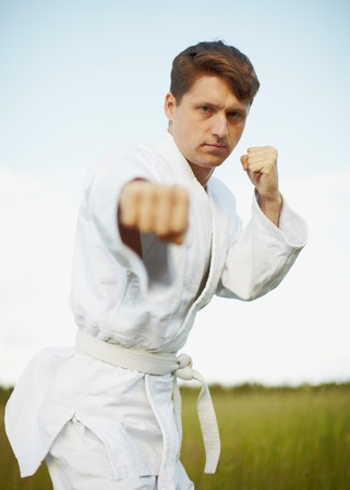 The young man is engaged in karate open-airの写真素材