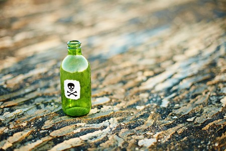 Green glass bottle from a poison on the groundの写真素材