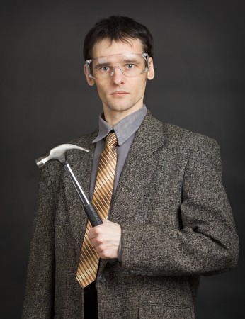 The young man in goggles keeps in readiness a hammerの写真素材