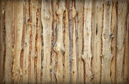 Coarse rural wooden fence made of boards and slabs - the backgroundの写真素材