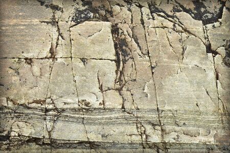 Surface of a natural stone with stains and cracks - a backgroundの写真素材