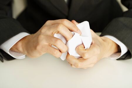 Man's hands crumpling a white paper close upの写真素材