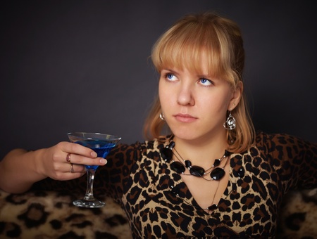 A beautiful young girl tries to exotic drink on black backgroundの写真素材